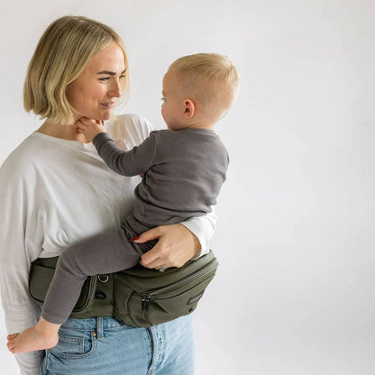 Tushbaby Hip Carrier for baby and toddler with adjustable straps and ergonomic design, worn around parent's waist.