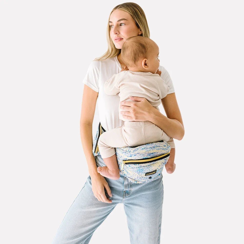 Baby wearing Tushbaby Hip Carrier by Tushbaby, showing ergonomic design and comfortable fit for parents and toddlers.