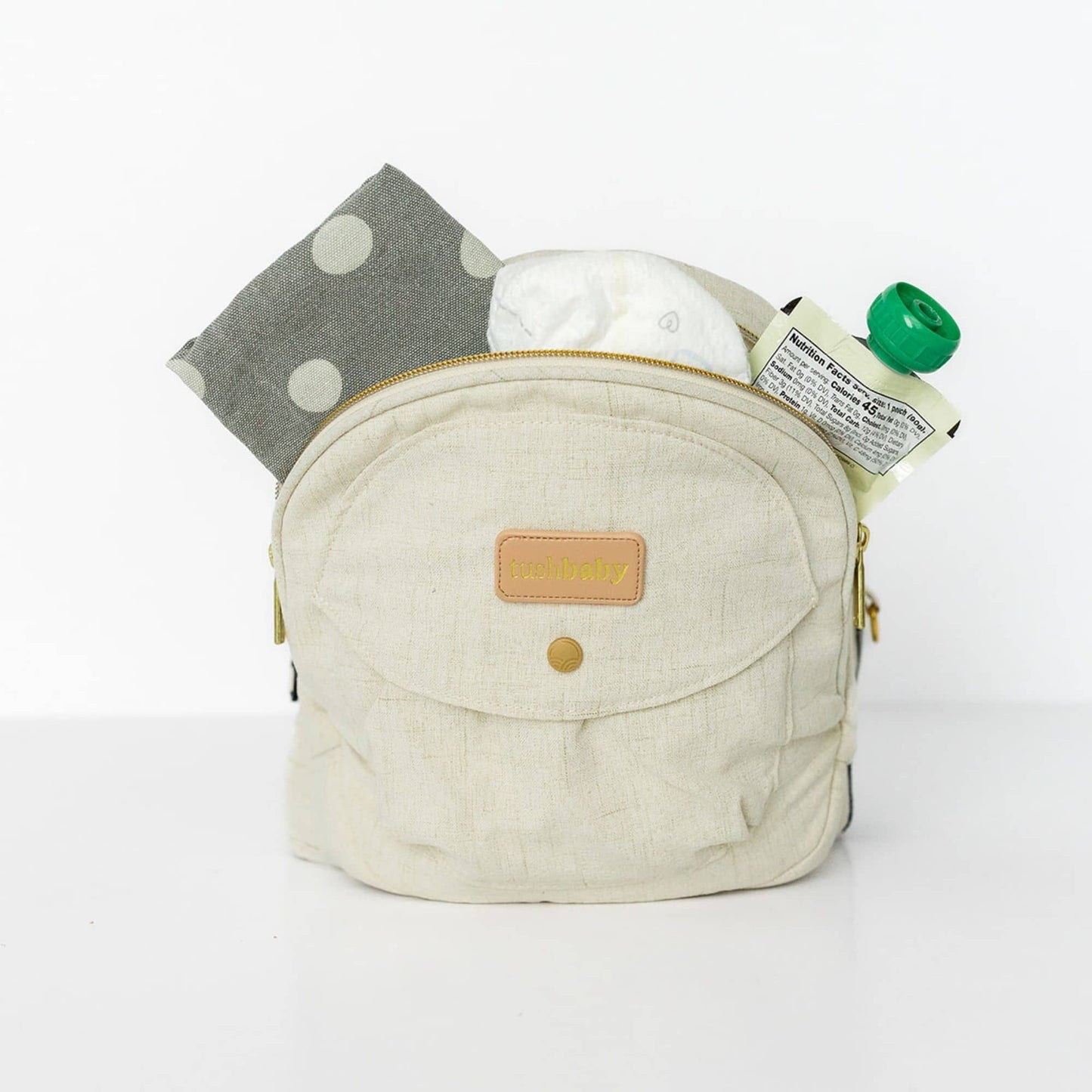 Baby sitting in the Tushbaby Hip Carrier, a comfortable and supportive baby carrier for toddlers by Tushbaby.