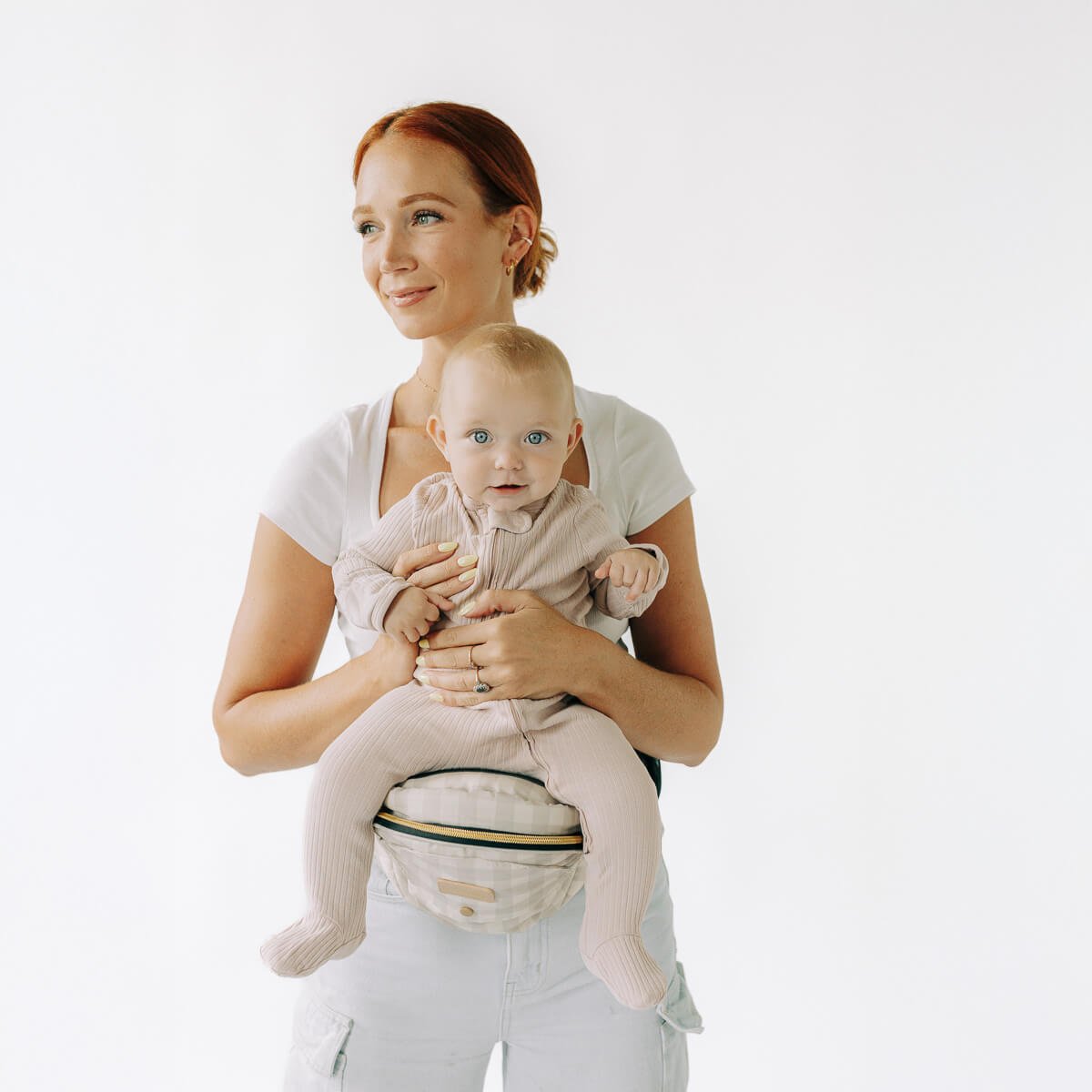 Tushbaby Hip Carrier for babies and toddlers showing adjustable straps and ergonomic design in a neutral color.